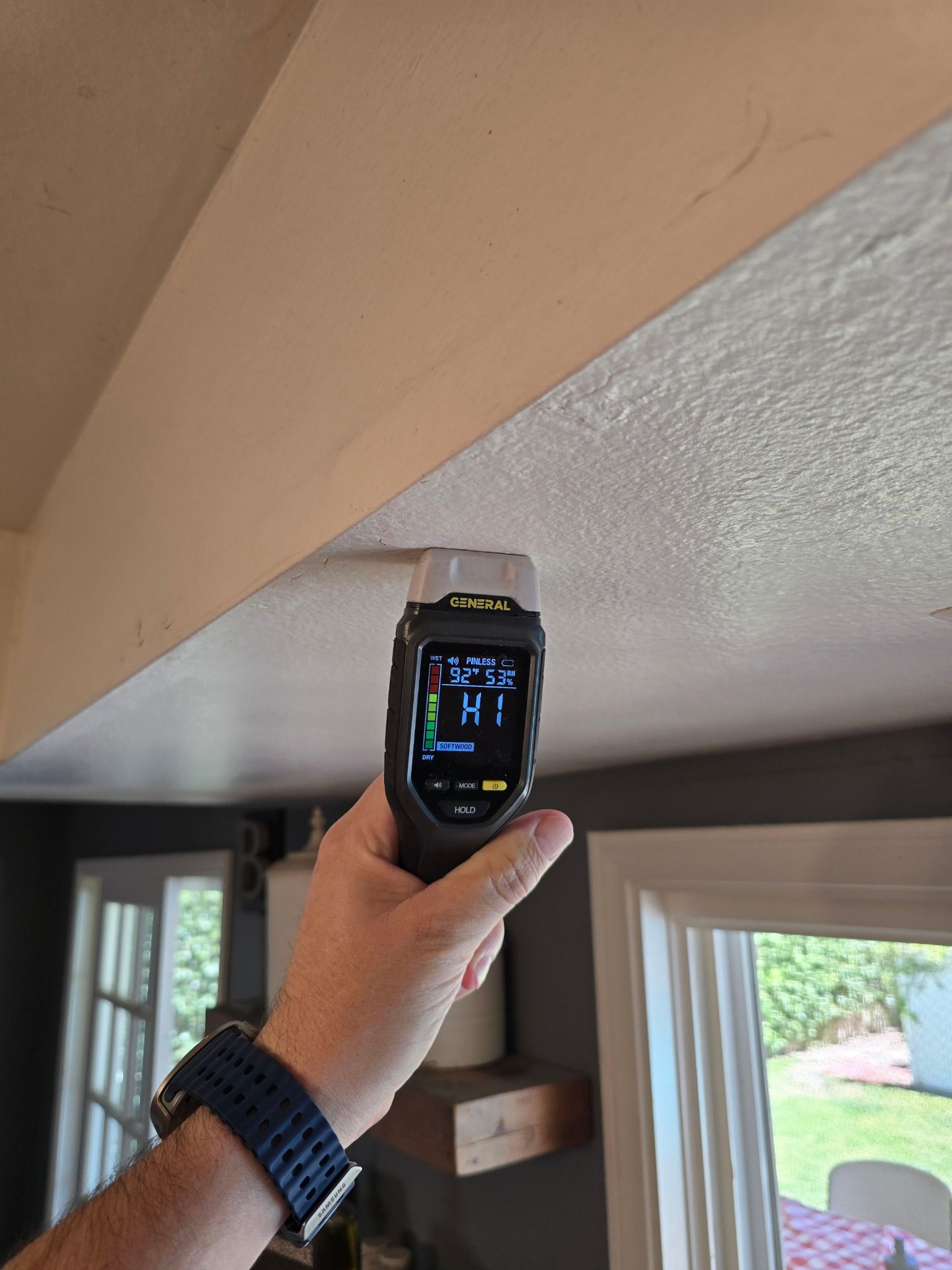 Moisture meter testing a ceiling